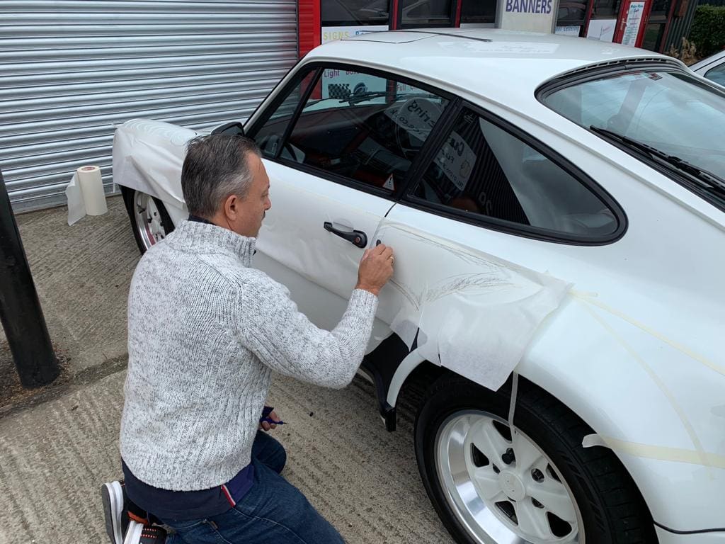 Phil masking out the Martini stripe outline by hand on the Porsche 911